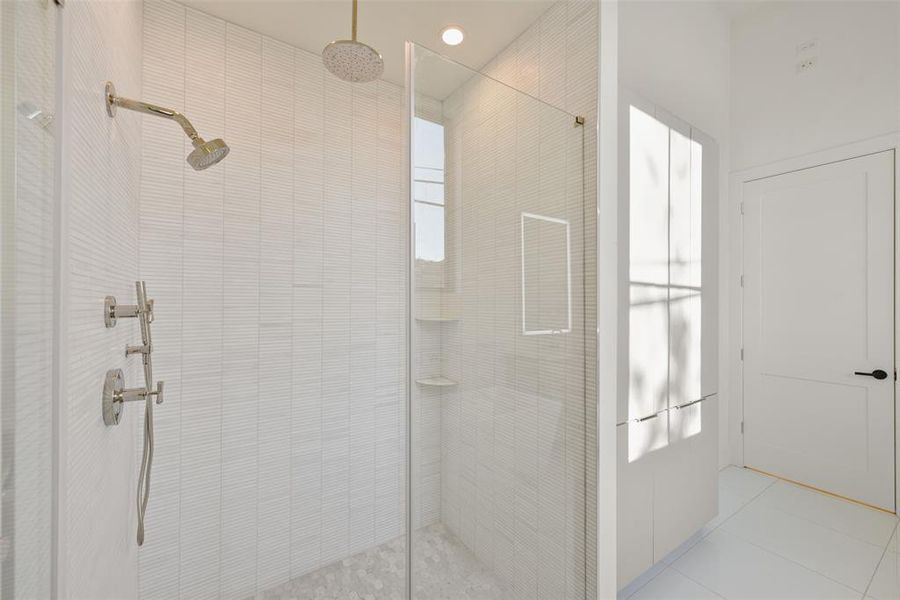 You will love this custom shower with rain shower, extended shower head and hand held wand all supplied by Ferguson's. The custom tile, glass wall and linear drain elevate the space.