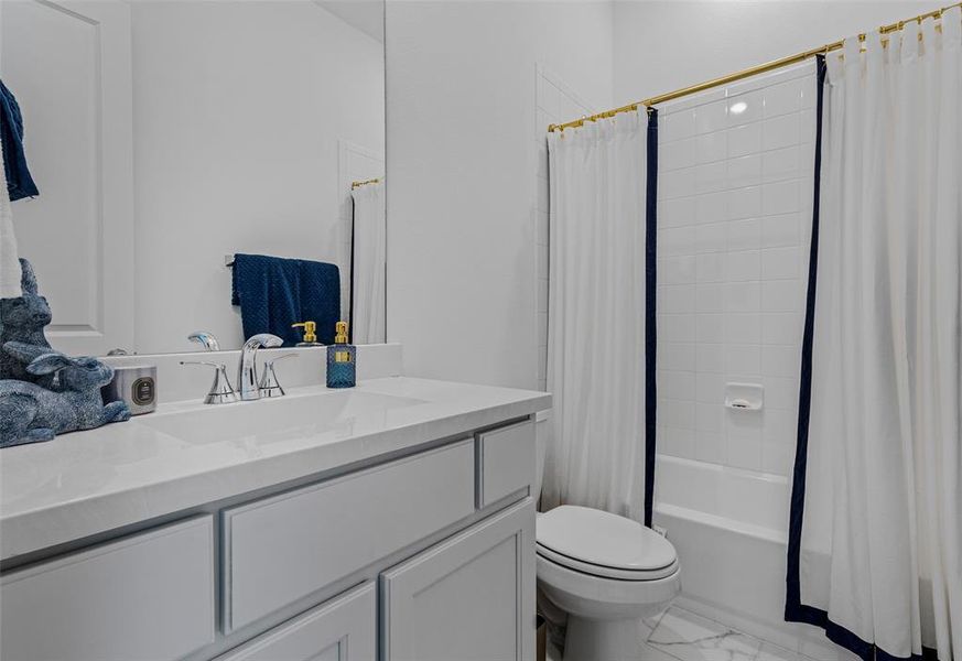 Full bathroom with vanity, toilet, and shower / bath combo with shower curtain