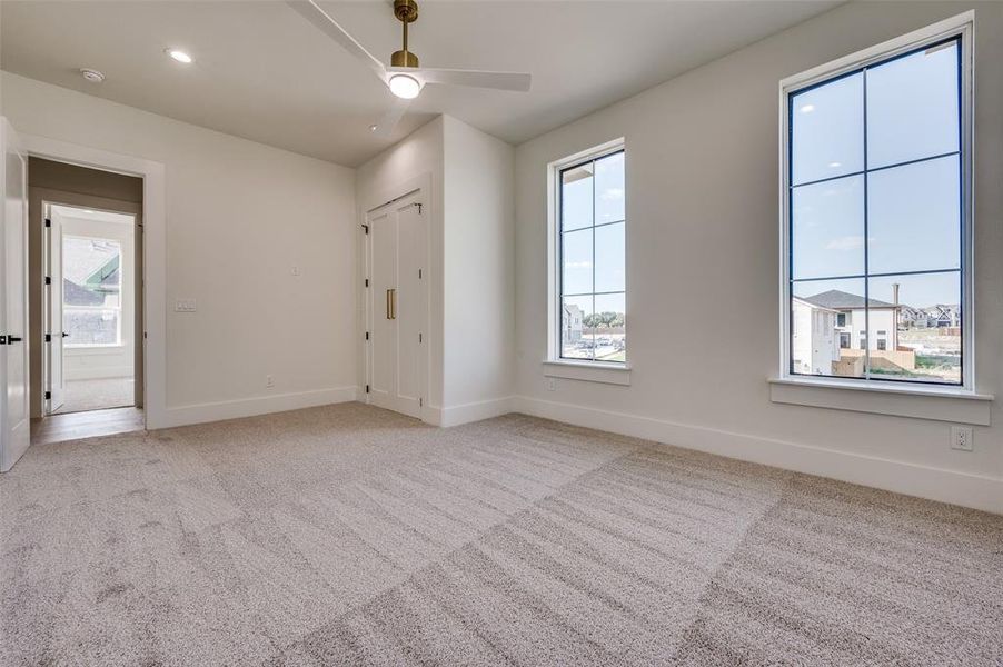 Empty room with light colored carpet and ceiling fan