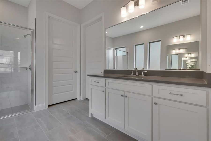 Bathroom with tile patterned floors, vanity, and a shower with shower door