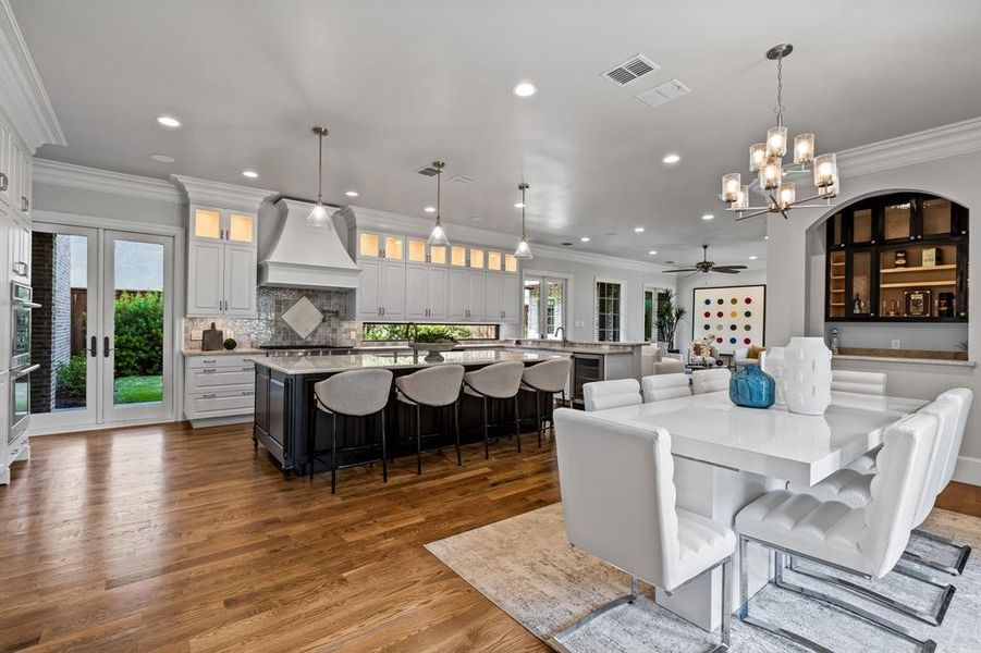 Dining area featuring ceiling fan with notable chandelier, a healthy amount of sunlight, and dark hardwood / wood-style floors