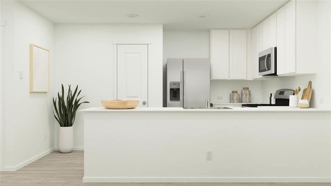 Kitchen featuring white cabinets, sink, kitchen peninsula, stainless steel appliances, and light hardwood / wood-style floors