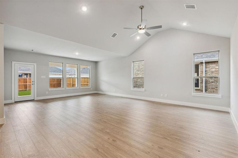 Unfurnished living room with ceiling fan, light hardwood / wood-style floors, and vaulted ceiling