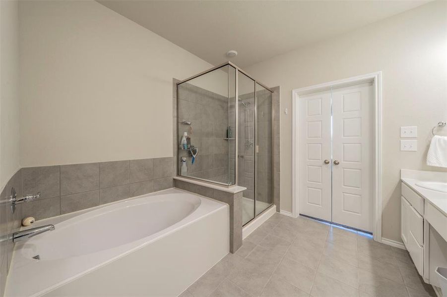 Bathroom with vanity, separate shower and tub, and tile patterned flooring