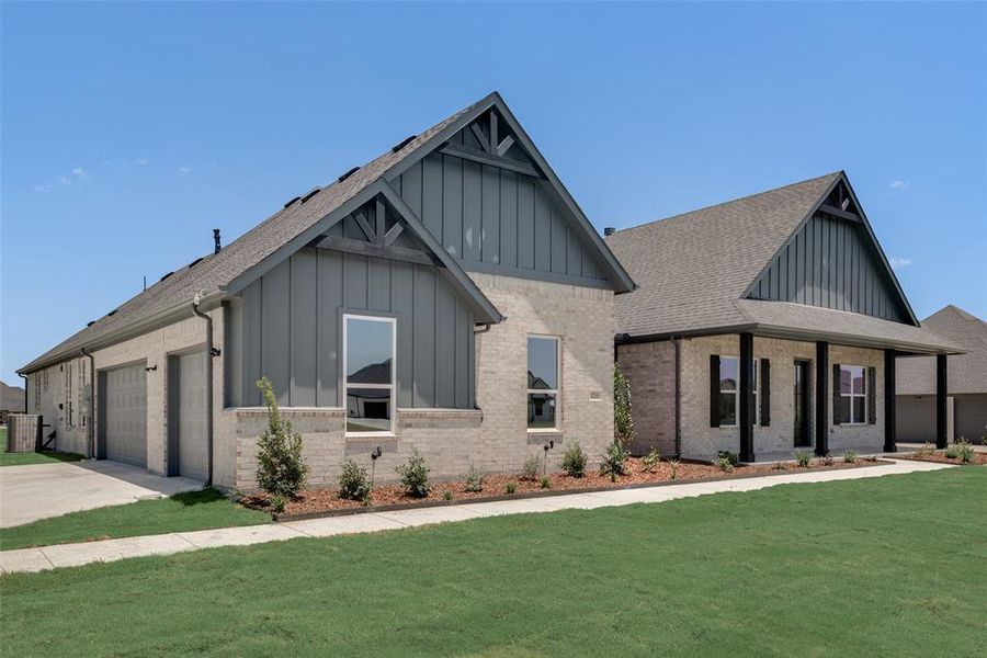 View of front facade featuring a garage and a front yard