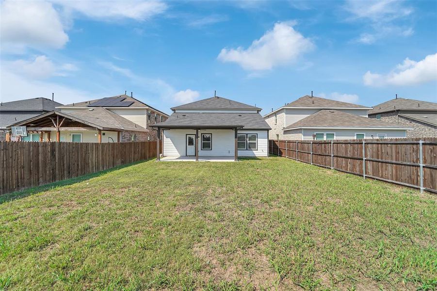 Rear view of property featuring a lawn and a patio area