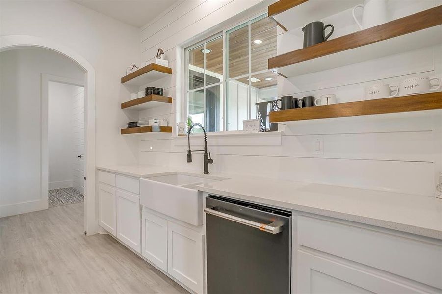 Kitchen featuring sink, light hardwood / wood-style flooring, dishwasher, and white cabinets