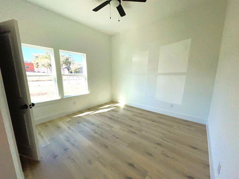 Unfurnished room with light hardwood / wood-style floors and ceiling fan