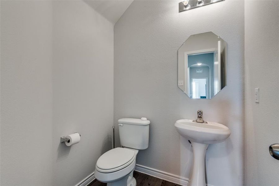 Bathroom featuring lofted ceiling, hardwood / wood-style floors, and toilet