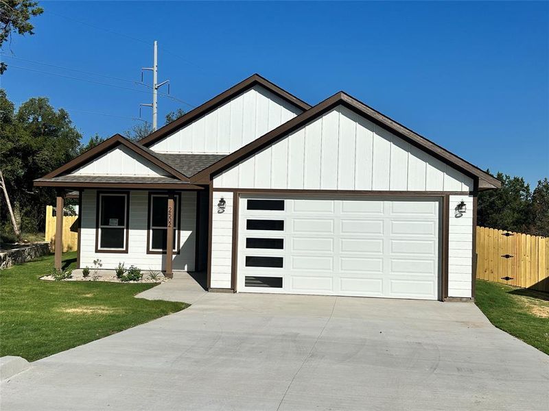 View of front of home with a garage and a front yard