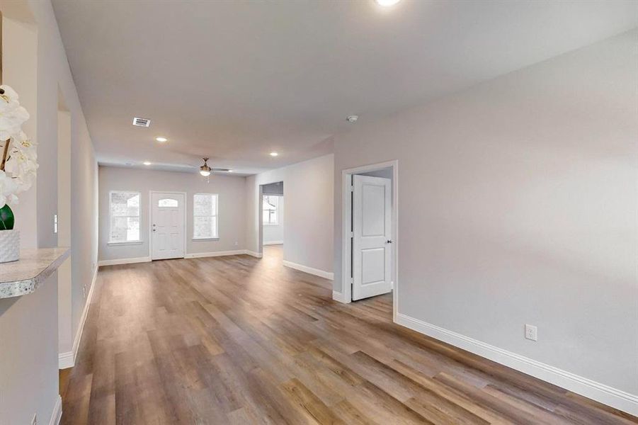 Unfurnished living room with ceiling fan and light wood-type flooring