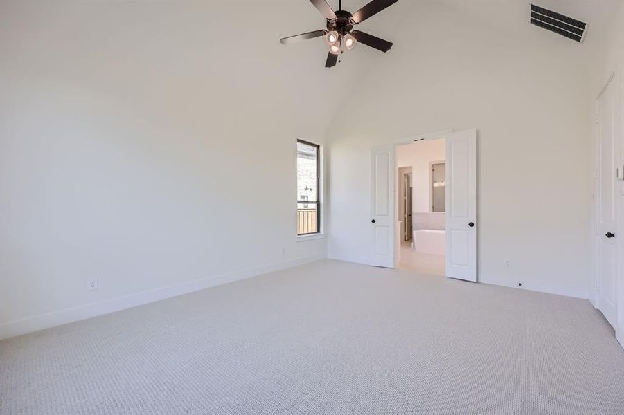 Unfurnished bedroom with light carpet, high vaulted ceiling, and ceiling fan