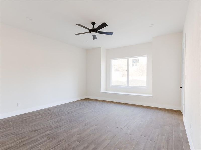 Spare room featuring ceiling fan and light wood-type flooring