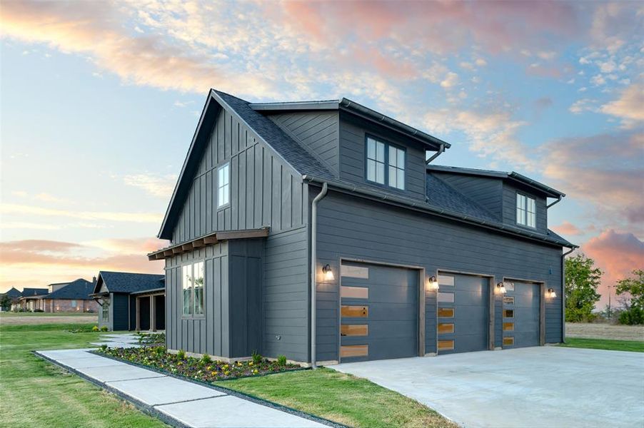 View of front of home featuring a garage and a lawn