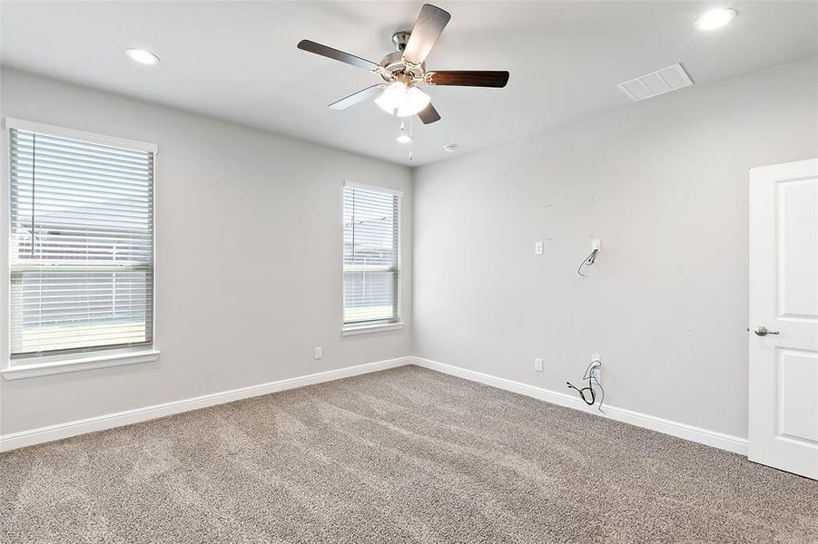 Carpeted empty room featuring ceiling fan