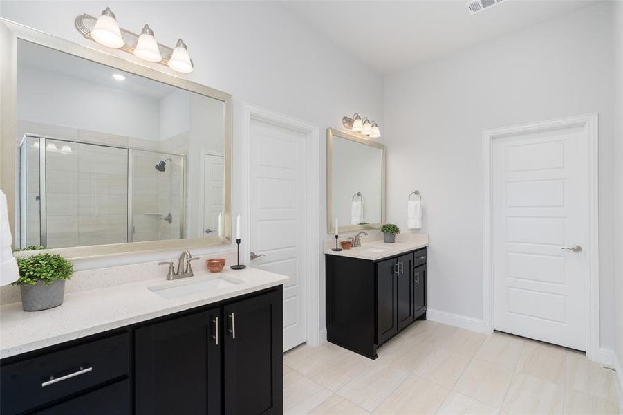 Bathroom with vanity, an enclosed shower, and tile patterned floors