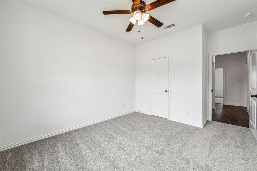 Unfurnished bedroom featuring carpet floors and ceiling fan