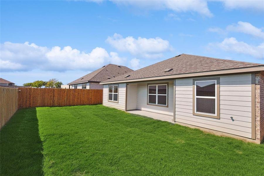 Rear view of house with a lawn and a patio area