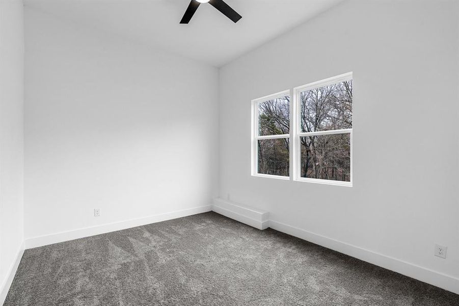 Empty room featuring carpet flooring and ceiling fan