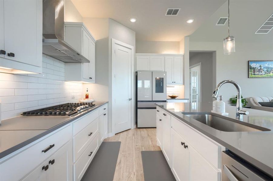 Kitchen featuring sink, stainless steel appliances, tasteful backsplash, and wall chimney exhaust hood