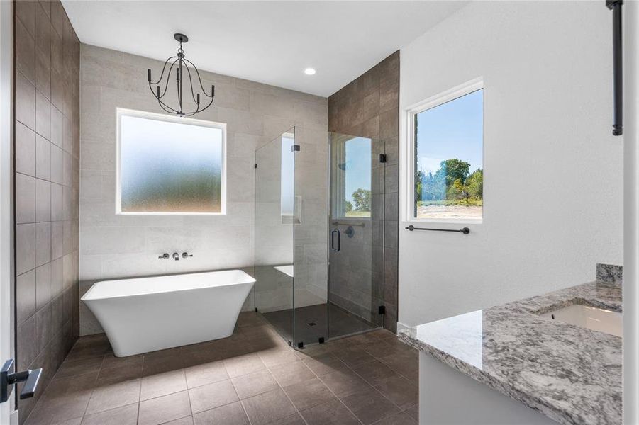 Floor to ceiling tile surrounds the luxurious soaking tub and walk-in shower.