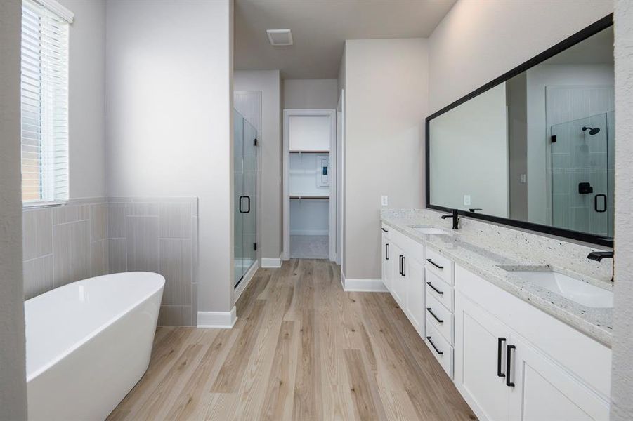 The en-suite master bath showcases granite countertops, dual sinks on a spacious vanity, a soaking tub and a spacious shower.