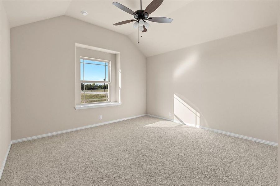 Carpeted spare room with lofted ceiling and ceiling fan