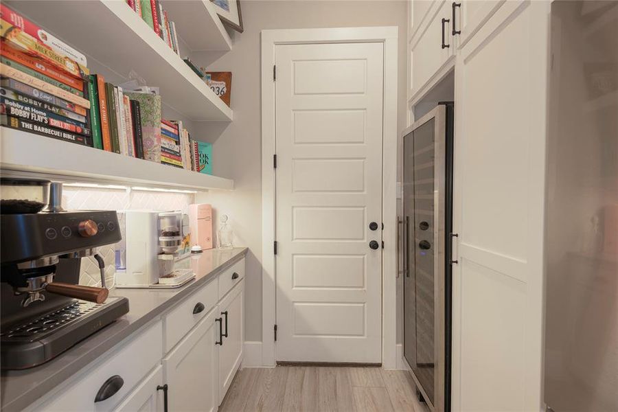 Kitchen with white cabinets and light hardwood / wood-style floors