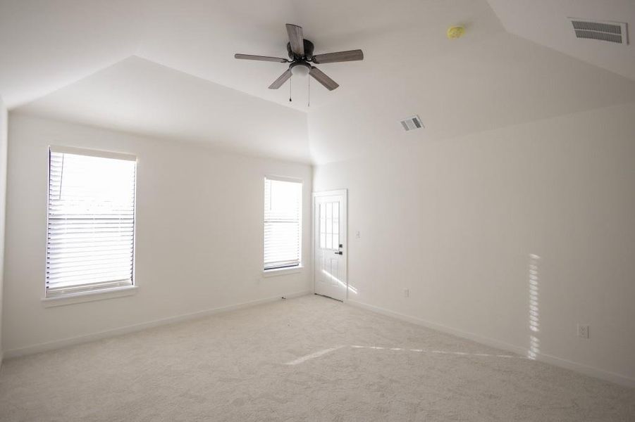 Unfurnished room featuring carpet flooring, ceiling fan, and vaulted ceiling