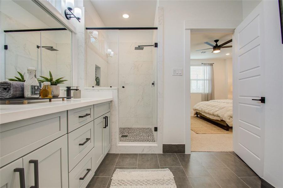 Gorgeous primary bathroom with quartz double sink vanity and a big shower. Photos from another community by the same builder, FINISHES & FLOOR PLAN WILL VARY!