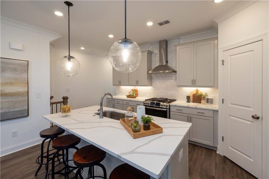 Kitchen featuring wall chimney range hood, decorative backsplash, dark hardwood / wood-style floors, and stainless steel range with gas stovetop , not the actual unit