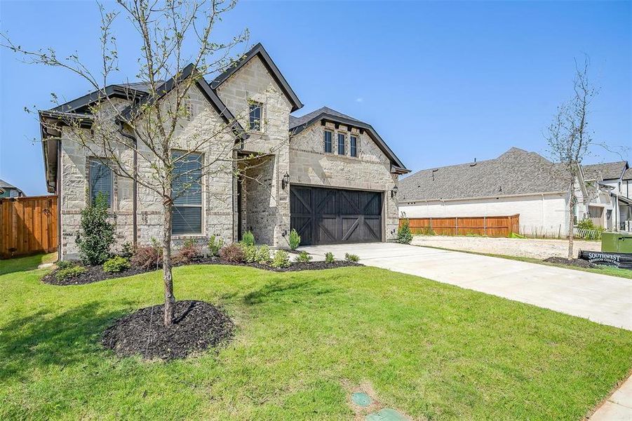 French country style house featuring a front lawn and a garage