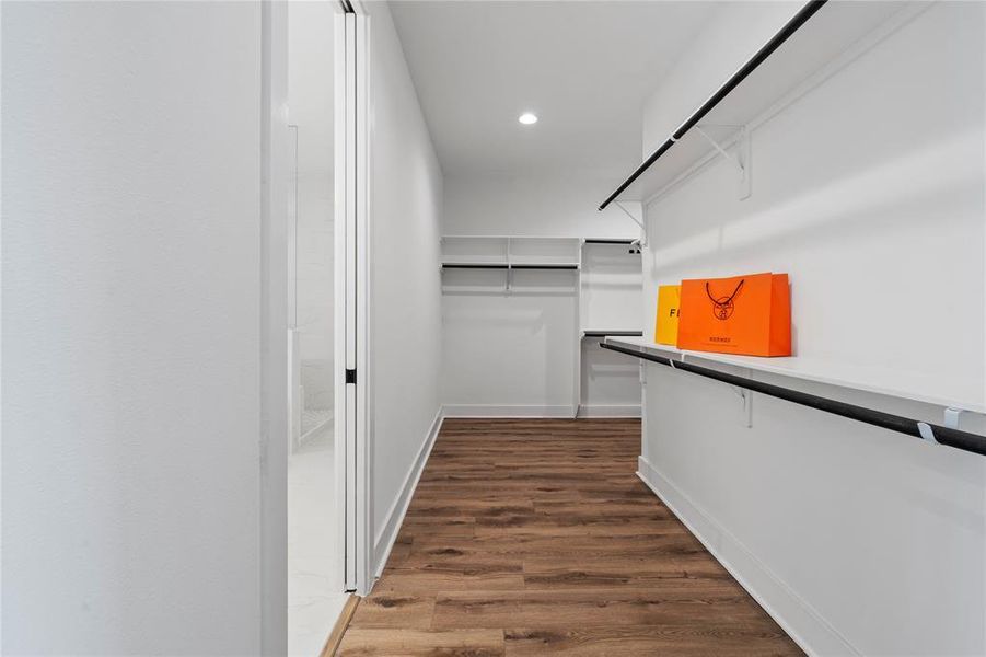 The primary closet’s entry reveals a spacious area that expands further, offering ample storage