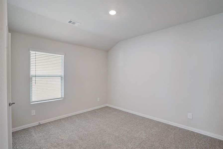 Bedroom with vaulted ceiling and carpet