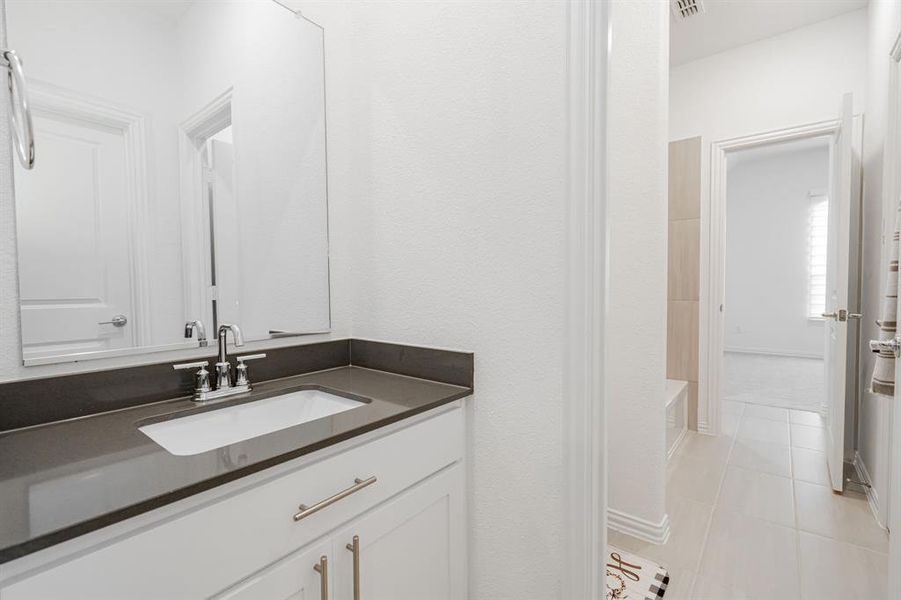 Bathroom featuring tile floors, shower / bath combination, and vanity