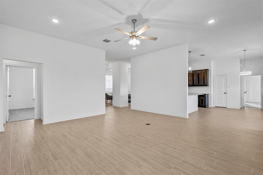 Unfurnished living room with light hardwood / wood-style floors, wine cooler, and ceiling fan