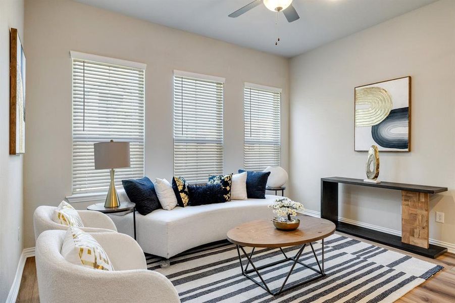 Living room with hardwood / wood-style flooring, ceiling fan, and a wealth of natural light