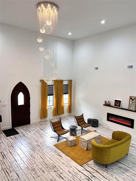 Living room with light hardwood / wood-style floors and a chandelier