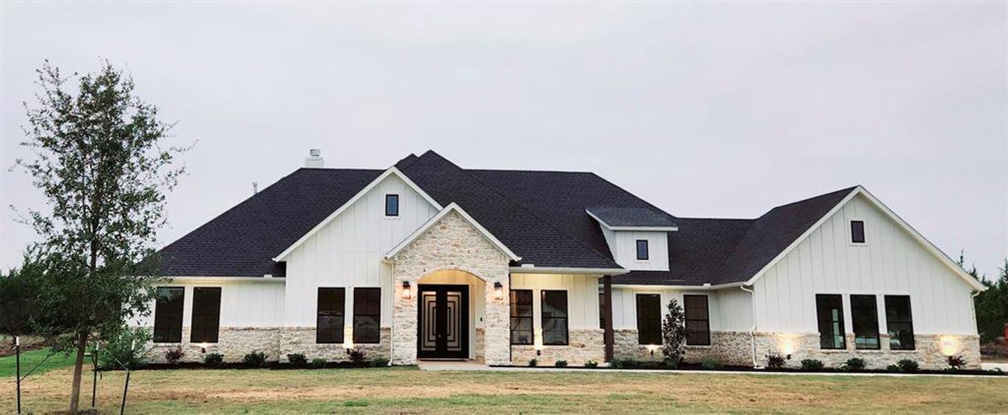 Modern farmhouse style home with a front lawn