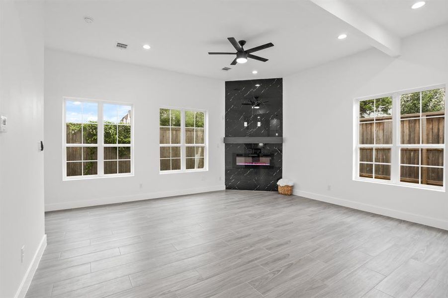 The living room features a beautiful black electric fireplace and recessed lighting to create the perfect relaxing ambiance.