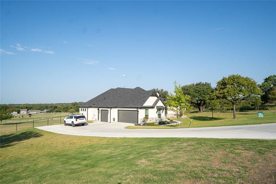 View of front of property featuring a garage and a front lawn