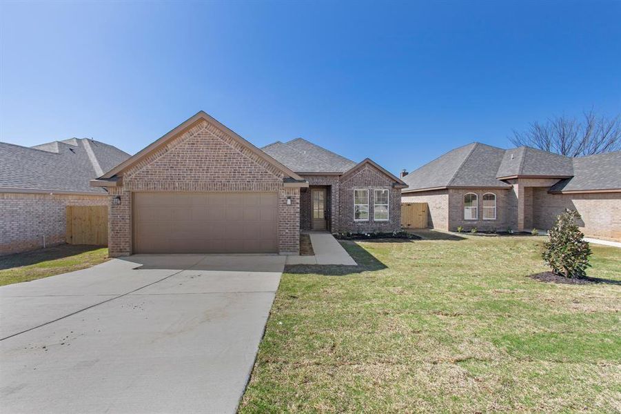 View of front of home featuring a front lawn and a garage