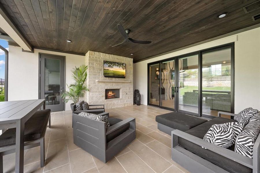 View of patio featuring an outdoor living space with a fireplace and ceiling fan