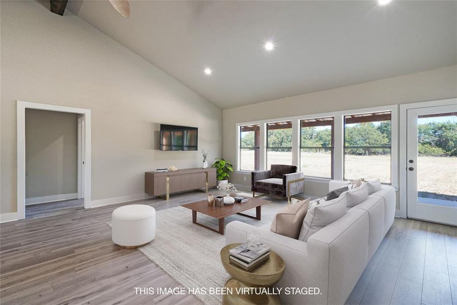 Living room featuring plenty of natural light, hardwood / wood-style floors, and high vaulted ceiling