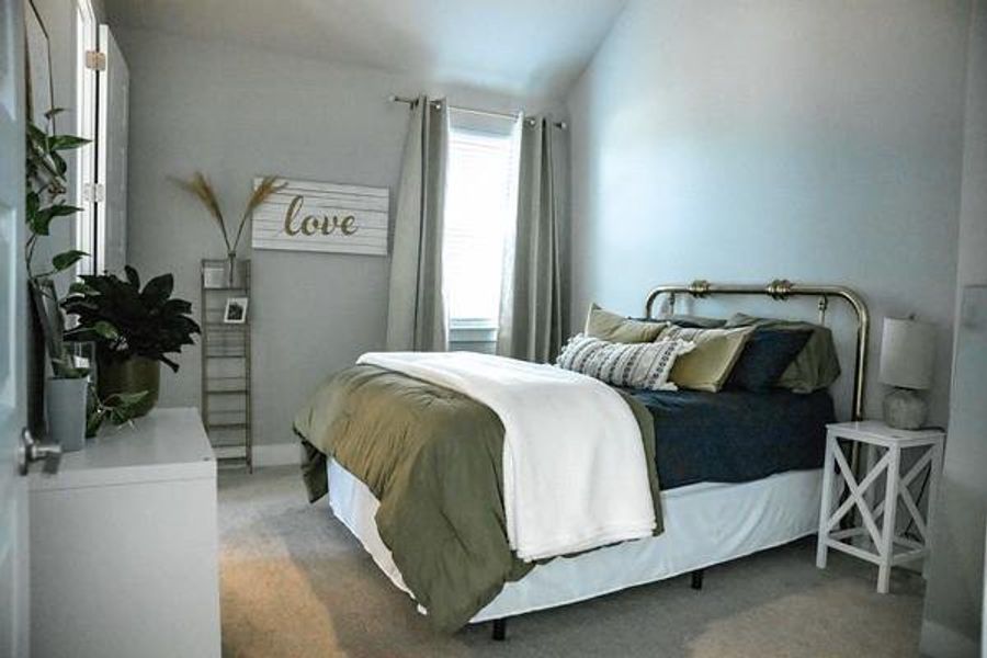 Bedroom with dark colored carpet and lofted ceiling