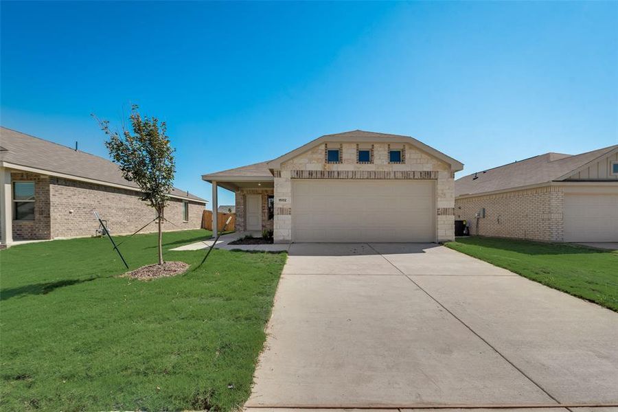 View of front of home featuring a front yard and a garage