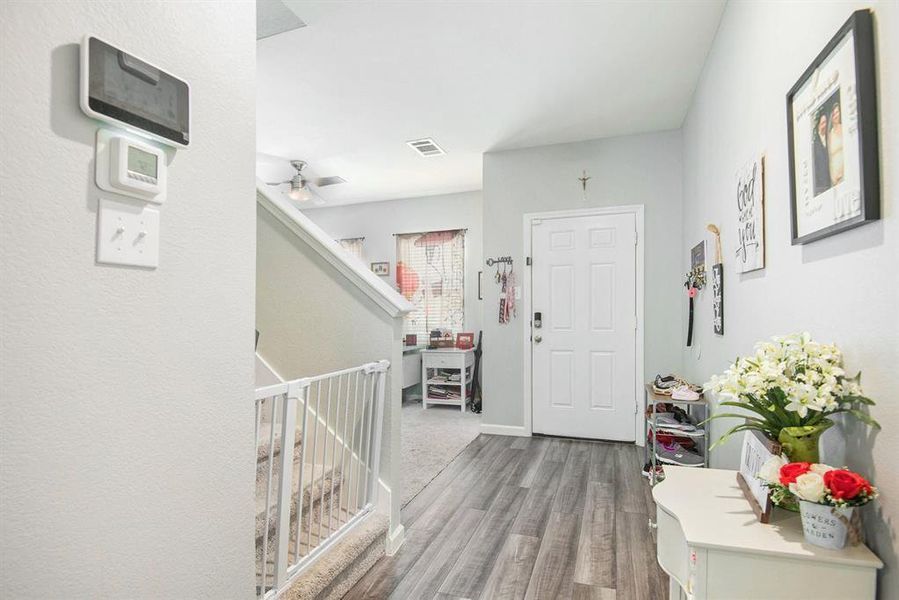 Foyer entrance with ceiling fan and light hardwood / wood-style floors