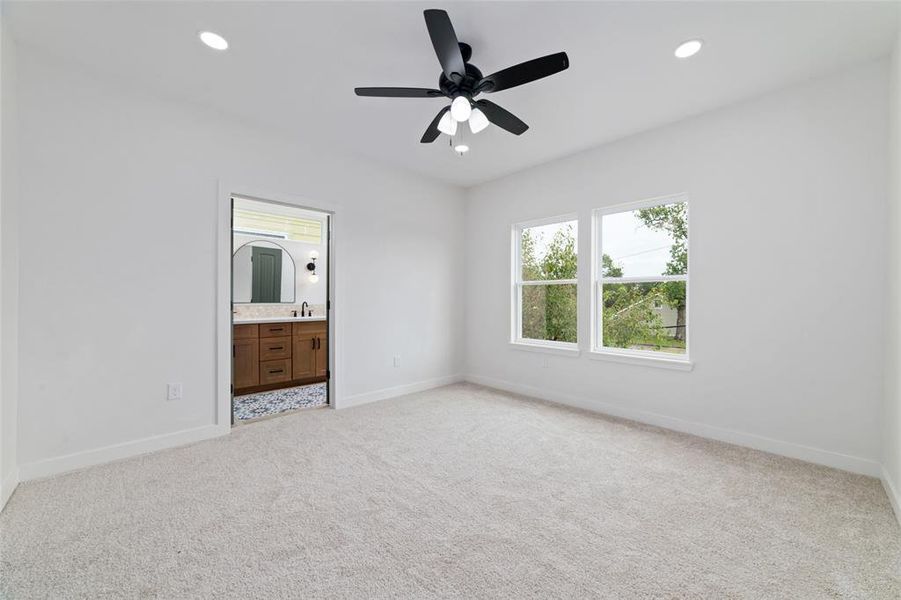 A primary bedroom with carpet, windows, offers a cozy and tranquil retreat. The carpet adds warmth and comfort underfoot, while the windows provide natural light and a view of the outdoors. With direct yard access, it's a perfect space to relax.