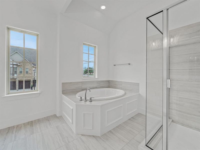 Bathroom featuring tile floors, plus walk in shower, and vaulted ceiling
