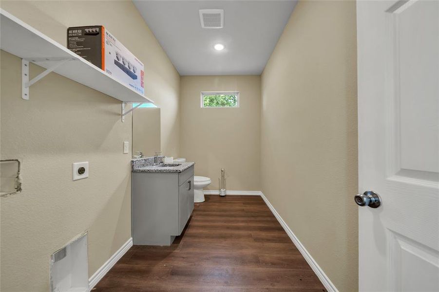 Laundry area with sink, dark hardwood / wood-style flooring, and electric dryer hookup